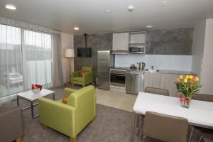 纳尔逊探索纳尔逊公寓的厨房和带绿色桌椅的客厅
