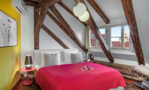 布拉格4 Arts Apartments by Adrez的一间带红色床的卧室,位于带木梁的房间
