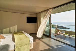 拉瑟White Rocks Hotel Kefalonia的一间卧室配有一张床,享有海景