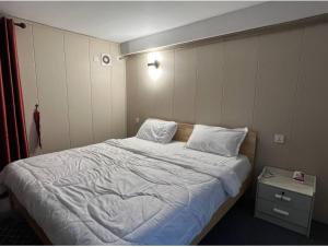 金边Whitehouse Guesthouse的卧室配有一张带白色床单和枕头的大床。