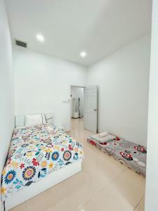 Yong PengEntire 4 BDR white house @ Yong Peng的一间卧室配有一张带花卉棉被的床