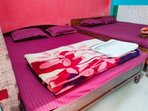 拉塔古里Hotel Green Gold Resort Lataguri的配有两张紫色和粉色床单的床铺