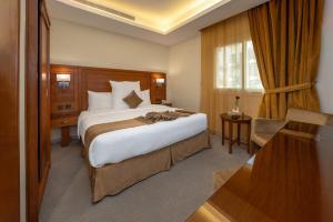 吉达فندق روز جدة 2的酒店客房设有一张大床和一张书桌。