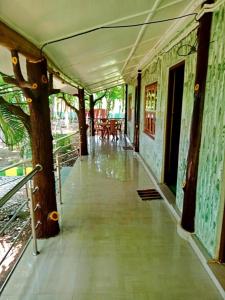 拉塔古里Hotel Green Gold Resort Lataguri的带有树和桌子的建筑物的走廊
