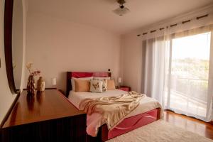 里韦拉布拉瓦Bairos House - Coastal Escape的一间卧室配有一张床、一张书桌和一个窗户。