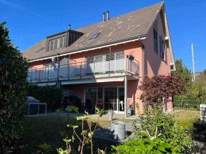 KnonauGemütliches Haus in Knonau的大型粉红色房屋设有大阳台