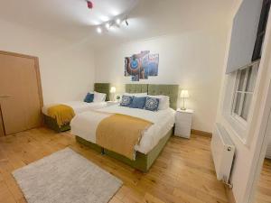 伦敦Angel x Kings Cross Hub的一间卧室设有两张床,墙上挂着一幅画
