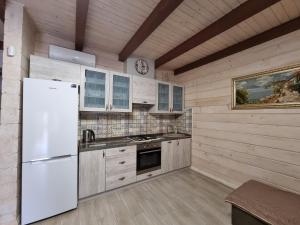 切尔诺莫斯克КОТТЕДЖ У МОРЯ的厨房配有白色冰箱和水槽