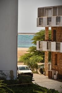 萨尔雷BoaOp Apartaments的一座在海滩上停有车的建筑