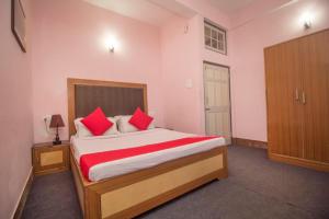 大吉岭Hotel North Point Inn Darjeeling的一间卧室配有一张带红色枕头的大床