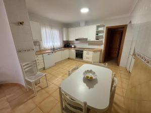 多列毛利诺斯Gran villa en Torremolinos的厨房配有白色的桌椅、白色的桌子和椅子