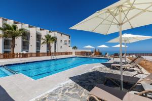 斯法卡基White Olive Elite Rethymno的酒店前方的游泳池配有椅子和遮阳伞