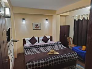 大吉岭GRG Mountview By Darjeeling的酒店客房,配有带帽子的床