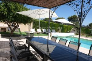 Pugetvery beautiful villa with private pool in the luberon enjoying a magnificent view of the durance valley, located in puget – 10 people.的一个带桌椅的庭院和一个游泳池