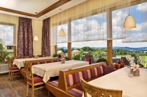 瓦尔德明兴格鲁伯兰德酒店的餐厅设有两张桌子和大窗户