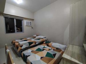 宿务Sunvida Tower Across SM City Cebu的带窗户的客房内设有两张单人床。