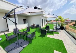 MadinaThe cozy standard studio的庭院设有草地、椅子和遮阳伞。