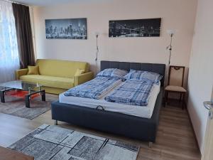 科马罗姆Kaptár lakás的一间卧室配有一张床和一张沙发