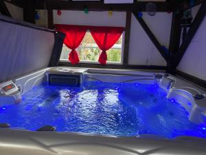 Saint-Aubin-de-Lanquaisgîte en pierre le paradis jacuzzi piscine Périgord pourpre 9km de bergerac的客房内的大浴缸里装满了蓝色的水