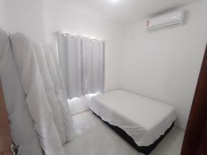 皮廷布Paraíso Praia Bela的白色的客房设有床和窗户。