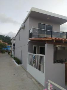 塞尔苏拉穆斯州长镇Casa do Píer的白色的房子,设有门廊和阳台
