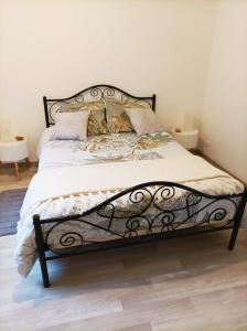 拉加西利Panoramique floral的一张带黑色金属框架和枕头的床