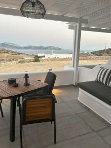 考弗尼西亚SOPHILIA SUITES的露台配有桌子和沙发,享有海滩美景