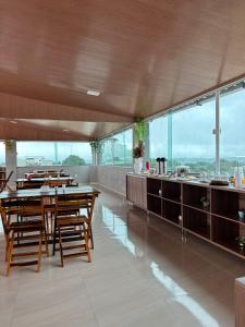 IbiapinaHotel Carvalho的一间带木桌和柜台的用餐室