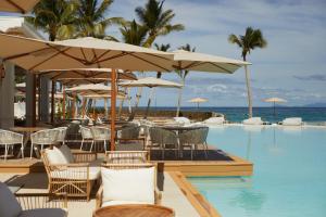 圣塔芭芭拉-山美纳Cayo Levantado Resort - All Inclusive的一个带桌椅和遮阳伞的游泳池