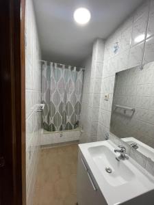 巴埃萨APARTAMENTOS LEONOR的白色的浴室设有水槽和淋浴。