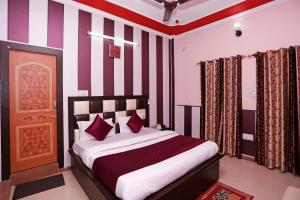 JwālāpurMehfil Hotel的一间卧室配有一张红色和白色条纹的床