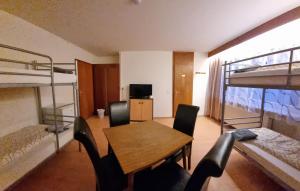 卡尔斯巴德Monteurzimmer - Karlsbad的客房设有餐桌和双层床。