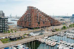 奥胡斯Seaside apartment with magical balcony view的一座大型红砖建筑,毗邻一个码头,有船