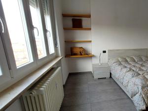 阿斯蒂Sesto Piano Apartment的一间卧室配有床、暖气和窗户