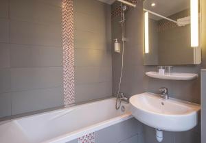 巴黎格兰德酒店的浴室配有盥洗盆和浴缸。