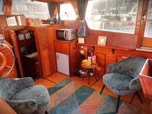 阿姆斯特丹Motorjacht Flint的厨房配有两把椅子和船上的微波炉