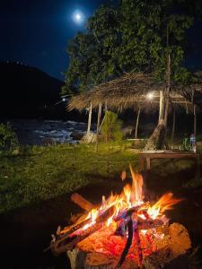 BālākotTwo-Bedrooms Suite At Country Club Balakot的夜间水边草地上的火坑