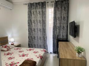 达喀尔CHEZ CODOU FANN - POINT E的一间卧室配有一张床、一张桌子和一个窗户。