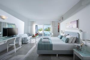 斯加雷塔Rethymno Mare Royal & Water Park的白色的客厅配有床和书桌