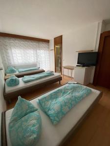 卡尔斯巴德Monteurzimmer - Karlsbad的客房设有两张床和一台平面电视。
