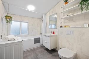 雷克雅未克Venture Vacations - Best Possible Location-Laugavegur Luxury Loft的白色的浴室设有浴缸、卫生间和水槽。