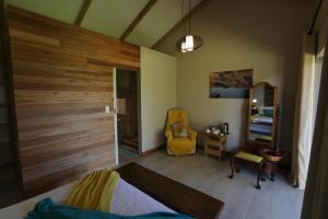 普利登堡湾Gemstone Farm的一间卧室设有木墙和黄色椅子