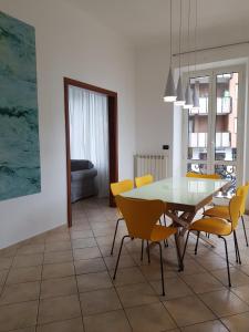 瓦拉泽La Terrazza Apartment,a 50 mt dal mare的一间设有玻璃桌和黄色椅子的用餐室