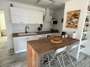 圣地亚哥港SUL MARE的厨房配有木桌和白色橱柜。
