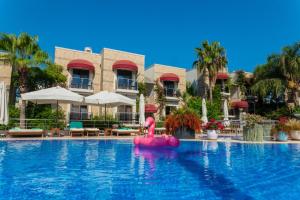 博德鲁姆Bodrium Hotel & Spa的度假村的游泳池,中间有粉红色的火烈鸟
