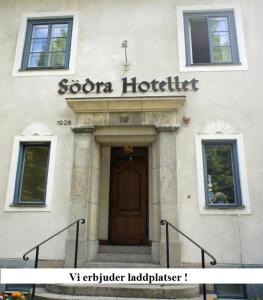 诺尔雪平Södra Hotellet的一座有门和酒店标志的建筑