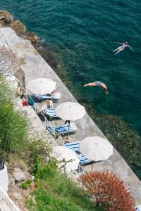 伊斯基亚米拉马雷海Spa度假酒店的一群雨伞和在水中游泳的人