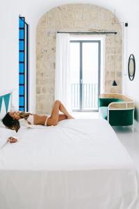 伊斯基亚米拉马雷海Spa度假酒店的躺在床上读书的女人