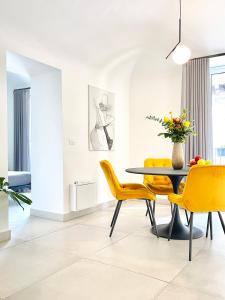 卡塔尼亚Sangiuliano Holiday Home的一间带桌子和黄色椅子的用餐室