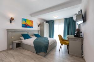 Sub CoastăSky Rooms by Volo Guest House的一间卧室配有一张床、一张书桌和一台电视